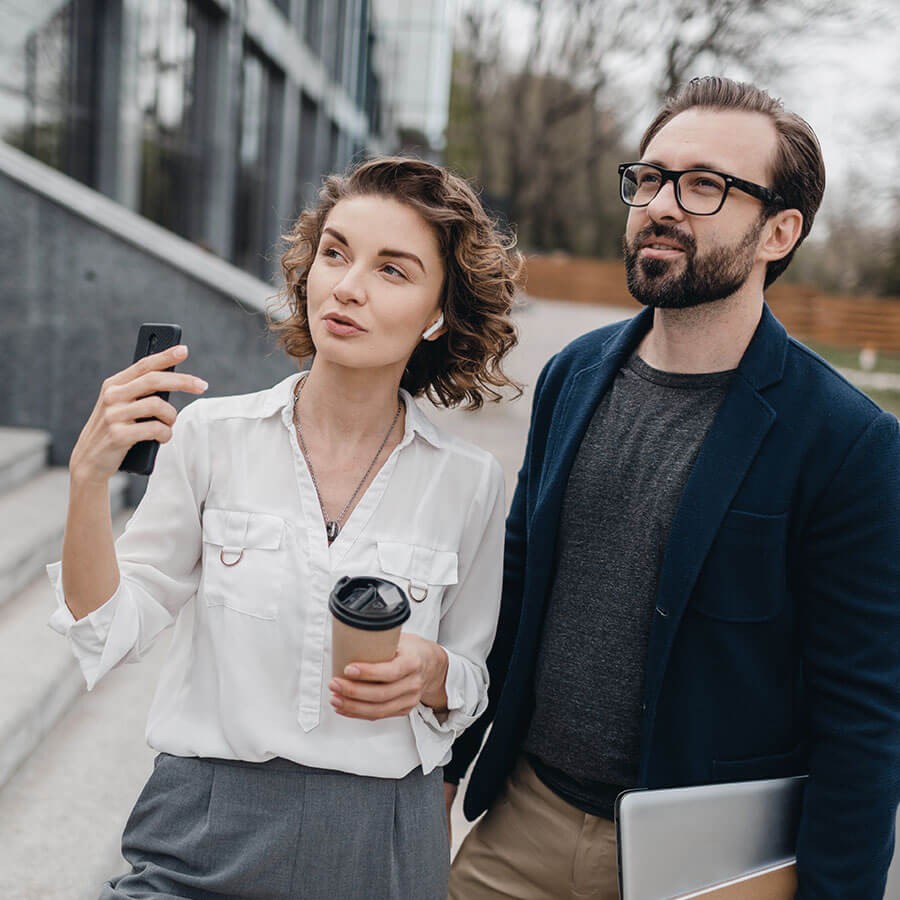 Une femme et un homme dans la rue examinant un bÃ¢timent Ã  acheter